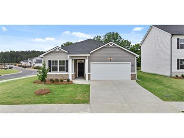 Gray siding one-story home with a two-car garage and landscaping at 8589 Seabiscuit Rd, Lithonia, GA 30058