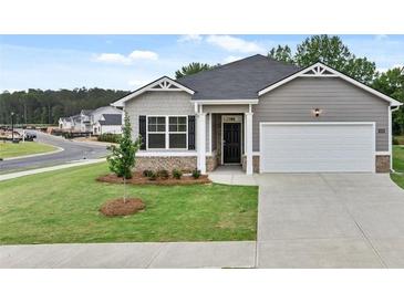 Charming single-story home with well-manicured lawn and attached two car garage at 8589 Seabiscuit Rd, Lithonia, GA 30058