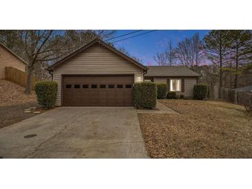 Tan house with brown garage door, driveway, and manicured bushes at 546 Paden Dr, Lawrenceville, GA 30044