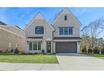 Two-story light brick home with dark brown garage door and manicured lawn at 3921 Enclave Way, Tucker, GA 30084