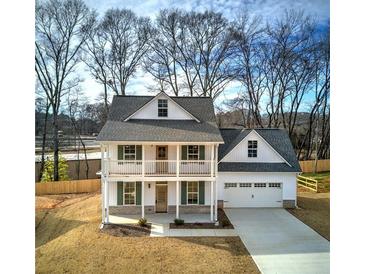 Two-story farmhouse with front porch, attached garage, and landscaped yard at 96 Rome St, Temple, GA 30179