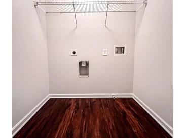 Bright laundry room with dark wood-look flooring and built-in shelving at 2429 Sardis Chase Ct, Buford, GA 30519