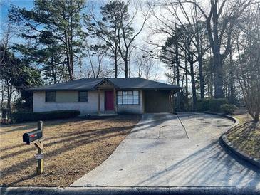 Ranch house with red door, driveway, and mature trees at 785 Jett Rd, Jonesboro, GA 30236