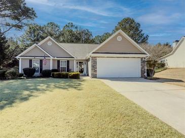 Charming one-story home featuring a well-manicured front yard and a two-car garage at 340 Annslee Cir, Loganville, GA 30052