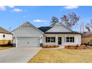 White farmhouse style home with a two-car garage and landscaped yard at 8950 Callaway Dr, Winston, GA 30187