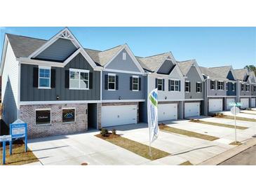 New townhome community with attached garages, driveways, and well-manicured lawns at 11559 Chatham Dr, Hampton, GA 30228