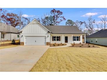 White farmhouse-style home with gray roof, stone accents, and a two-car garage at 8920 Callaway Dr, Winston, GA 30187