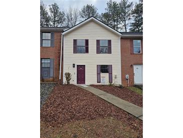 Two-story home featuring a beige facade, dark trim, and a walkway leading to the front door at 6002 Pat Mell Se Pl, Smyrna, GA 30080