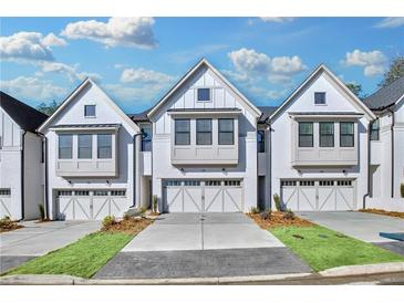 Three-story townhouses with white brick exteriors and two-car garages at 134 Briargate Dr, Johns Creek, GA 30097