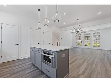 Open concept kitchen features an island with stainless steel oven and modern pendant lighting at 1779 Beckham Ne Pl # 58, Atlanta, GA 30324