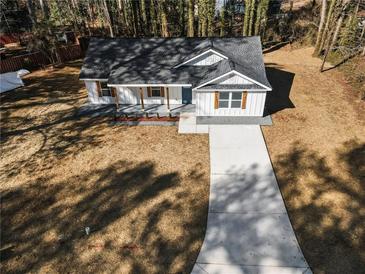 White house with a gray roof and a long driveway. Surrounded by trees at 2716 Battle Sw Trl, Marietta, GA 30064