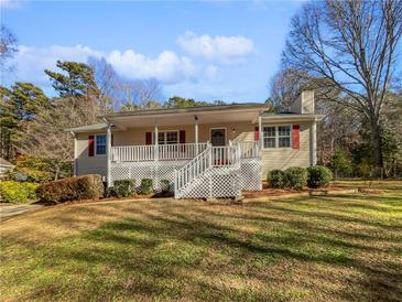 Ranch home with covered porch, white railings, and landscaped yard at 3123 Shiloh Pl, Canton, GA 30115