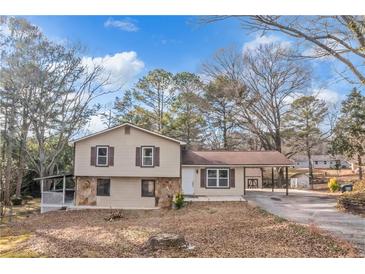 Two-story house with beige siding, stone accents, and carport at 2491 Crumps Landing Cir, Snellville, GA 30039