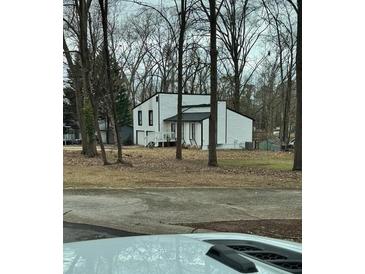 Two-story house with white siding, black accents, and a deck at 702 Talemwood Ct, Lawrenceville, GA 30044