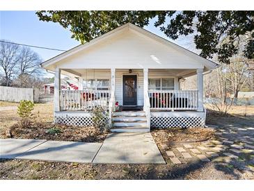 Charming white cottage with a spacious front porch at 3170 New Macland Rd, Powder Springs, GA 30127