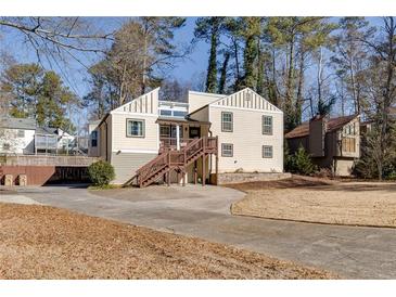 Inviting exterior of home featuring a wood deck and front yard with mature trees at 1775 Jody Ne Dr, Marietta, GA 30066