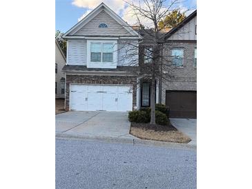 Two-story townhome with a two-car garage and landscaping at 3144 Spicy Cedar Ln, Lithonia, GA 30038