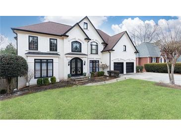 Stunning two-story house with a white exterior, black accents, and a beautifully landscaped lawn at 3000 Leeds Garden Ln, Alpharetta, GA 30022