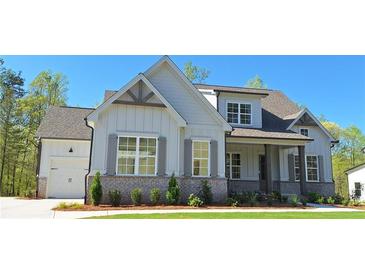 Charming home with light gray siding, brick accents, manicured lawn, and a two car garage at 4515 Aiden Way, Cumming, GA 30041