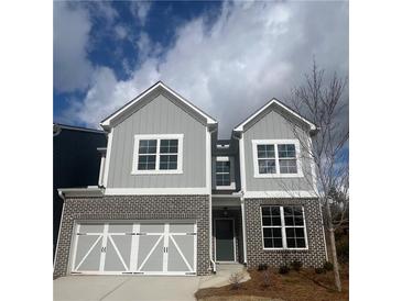 Charming two-story home with grey siding, brick accents, white trim, and a two-car garage at 269 Lakeside Pl, Canton, GA 30114