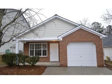 Brick and siding ranch home with a white garage door and small front porch at 6627 Coventry Pt, Austell, GA 30168