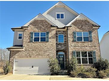 Brick two-story house with a three-car garage and landscaped yard at 416 Aristides Way, Canton, GA 30115
