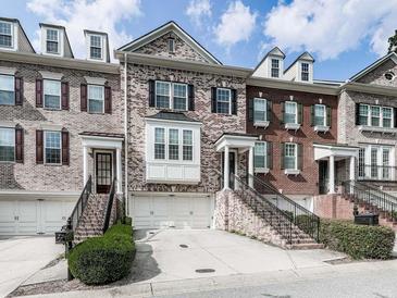 Brick front townhome with 2-car garage and landscaping at 5104 Waters Edge Trl, Roswell, GA 30075