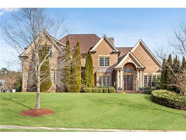 Brick house with stone accents, manicured lawn, and mature trees at 511 Baxter Way, Marietta, GA 30064