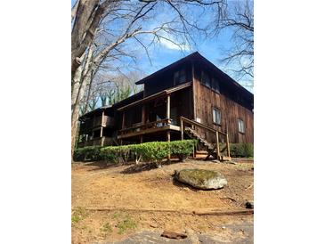 Two-story wood home featuring a covered porch with steps leading to the yard at 7 Quail Run, Decatur, GA 30035