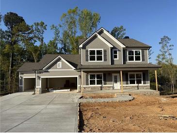 Charming two-story home with a welcoming front porch, attached two car garage, and manicured lawn at 1064 Cottonwood Ln, Loganville, GA 30052