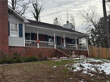 Charming brick home featuring a covered front porch with white railings and dark shutters at 2615 Leeshire Ct # 1, Tucker, GA 30084