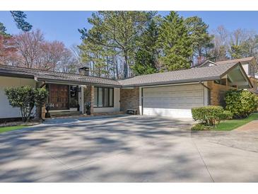 Charming home featuring a brick facade, a spacious driveway, and a two-car garage at 505 River Valley Rd, Sandy Springs, GA 30328