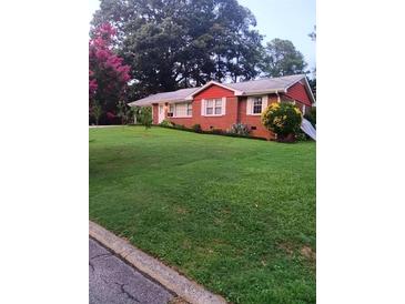 Brick ranch house with a spacious lawn and mature trees at 1577 Dellwood Circle, Morrow, GA 30260