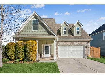 Two-story house with green siding, brick accents, and a two-car garage at 100 Orchard Ln, Covington, GA 30014