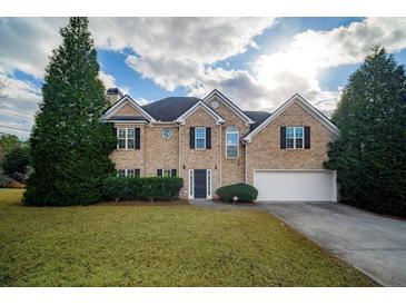 Brick house with 2-car garage, landscaping, and a spacious lawn at 286 Heathridge Se Ln, Mableton, GA 30126