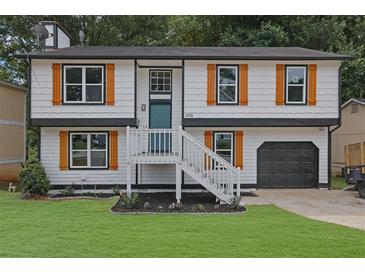 Two-story house with white siding, orange shutters, and a gray door at 4913 Windsor Downs Dr, Decatur, GA 30035