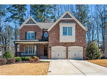 Charming brick home with well-manicured lawn, covered porch with swing, and two-car garage at 337 Ellis Preserve Sw Ln, Marietta, GA 30064