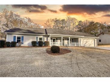 Ranch home with front porch, attached garage, and well-manicured lawn at 758 Shoreline Se Trl, Conyers, GA 30094