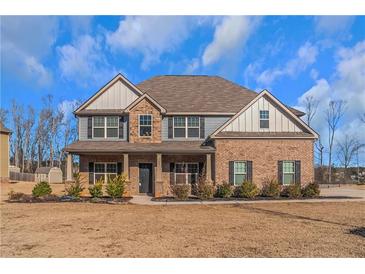 Two-story brick home with gray siding, a large front porch, and a landscaped yard at 149 Elkins Blvd, Locust Grove, GA 30248