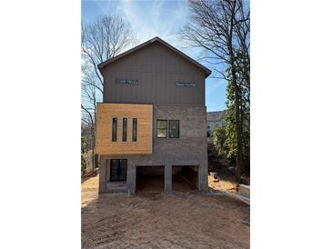 Modern two-story home featuring wood and gray siding and garage space on the ground floor at 120 N Gwinnett St, Buford, GA 30518