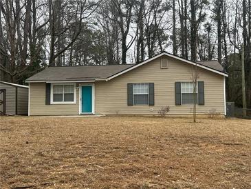 Charming single-story home features a manicured lawn and a delightful blue front door at 22 Cardinal Ln, Jonesboro, GA 30238