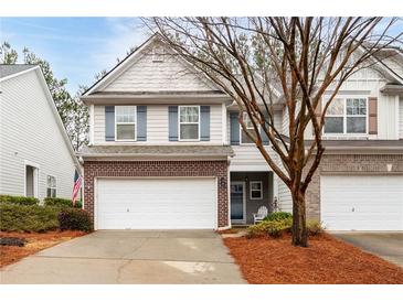 Two-story townhome with brick and siding exterior, two-car garage, and landscaping at 439 Mountain View Ln, Woodstock, GA 30188