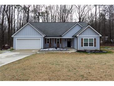 Gray house with a gray roof and a white garage door at 25 Water Oak Trl, Covington, GA 30014