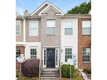 Brick townhouse exterior with a black metal front door and small landscaping at 2852 Vining Ridge Ter, Decatur, GA 30034