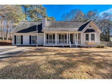 Ranch style home with white siding, front porch, and mature landscaping at 4620 Sammy Dr, Powder Springs, GA 30127