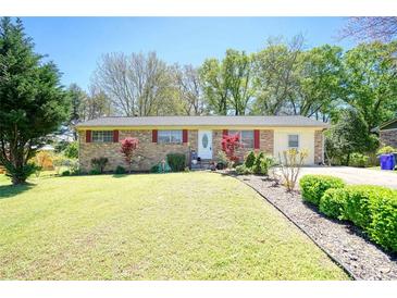 Brick ranch house with landscaped lawn and driveway at 981 Meadowbrook Nw Ln, Conyers, GA 30012