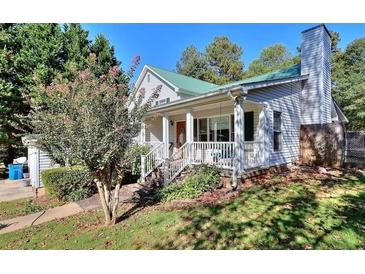 Charming home with a covered porch, green roof, beautiful yard and a well maintained exterior at 381 Mount Moriah Rd, Auburn, GA 30011