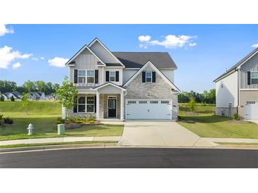 Charming two-story home with a mix of stone and siding, complemented by a well-manicured lawn at 13550 Whitman Se Ln, Covington, GA 30014