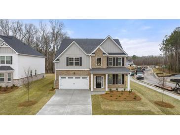 Two-story home with brick and siding, gray trim, and a two-car garage at 13218 E Tolstoy Se Drs, Covington, GA 30014