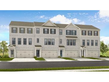 Three-story townhouses with neutral brick exterior, two-car garages, and landscaping at 216 Wilder Ridge Way, Lawrenceville, GA 30044